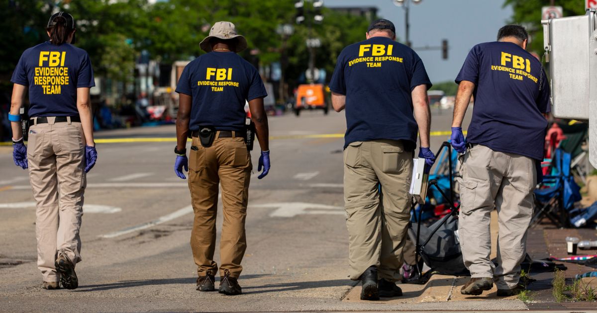 FBI Agents with the Evidence Response Team work the scene of a shooting in Highland Park, Illinois, on July 5, 2022.