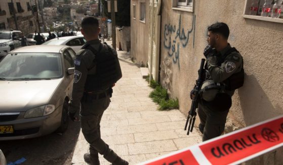 Police officers guard the scene where two Israelis were wounded in a shooting by a 13-year-old Palestinian boy in Jerusalem on Saturday.