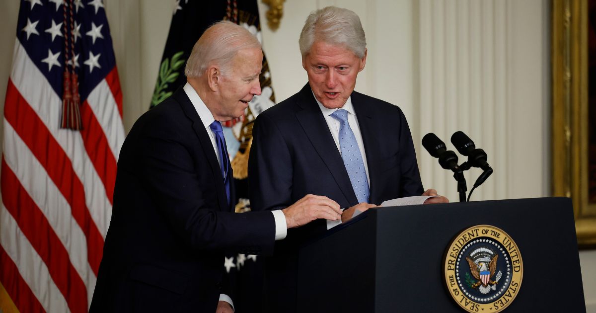 President Joe Biden, left, offers help to former President Bill Clinton during an event in the East Room of the White House on Thursday in Washington, D.C.
