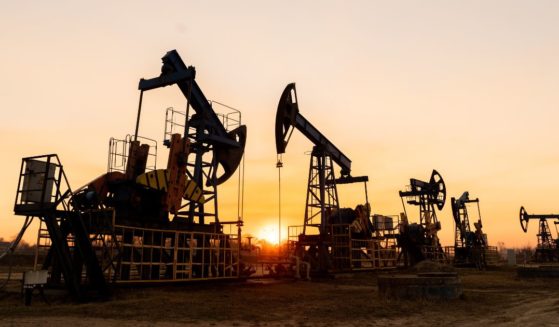 This stock photo shows oil pumps against the background of a sunset.