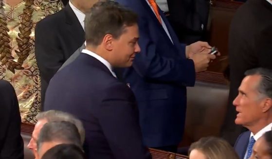 Utah Sen. Mitt Romney, right, was caught on camera in an elevated discussion with New York Rep. George Santos, left, ahead of Tuesday's State of the Union address in Washington.