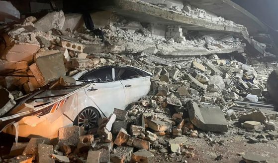 A car under the wreckage of a collapsed building