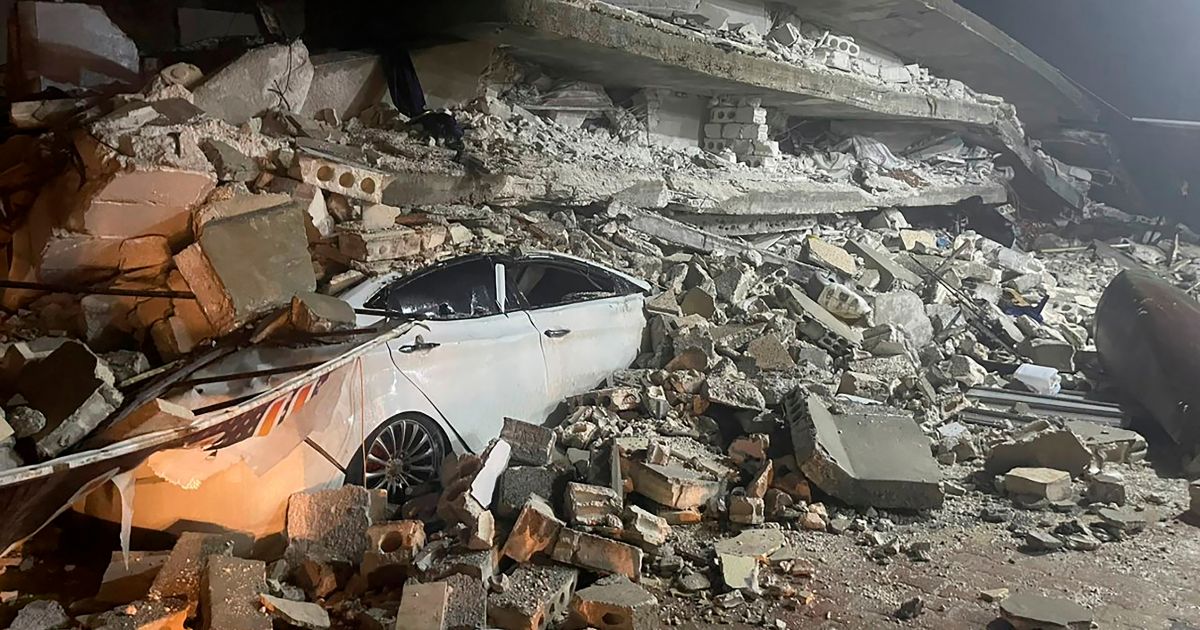 A car under the wreckage of a collapsed building
