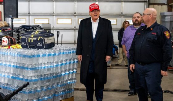 Former President Donald Trump stands next to a pallet of water bottles before delivering remarks at the East Palestine Fire Department station in East Palestine, Ohio, on Wednesday.