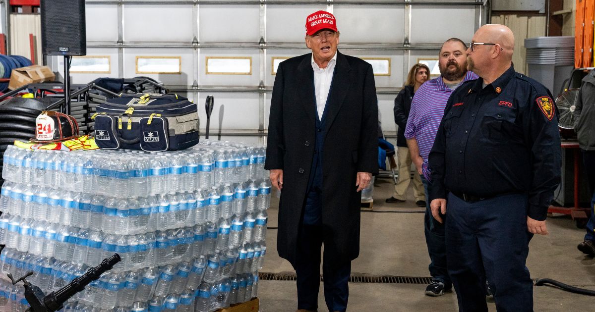 Former President Donald Trump stands next to a pallet of water bottles before delivering remarks at the East Palestine Fire Department station in East Palestine, Ohio, on Wednesday.