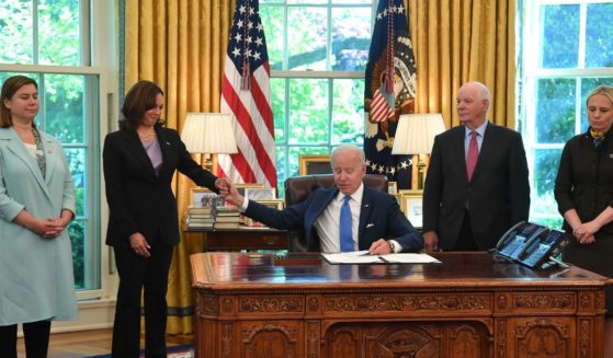 President Joe Biden holds the hand of Vice President Kamala Harris after signing into law the Ukraine Democracy Defense Lend-Lease Act of 2022 in the Oval Office of the White House on May 9, 2022. At far right is U.S. Rep Victoria Spartz, who left Ukraine in 2000.