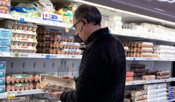 A shopper checking eggs before he purchases at a grocery store