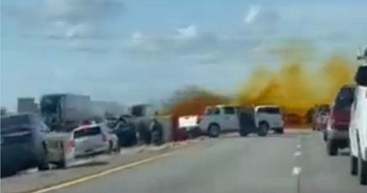 Crash-scene footage shows orange vapor rising over a highway packed with stopped vehicles.