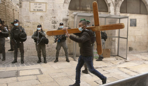 A Christian man carrying a cross along the Via Dolorosa