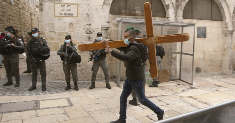 A Christian man carrying a cross along the Via Dolorosa