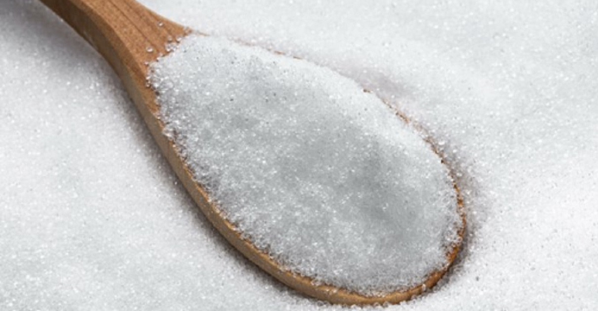A wooden spoon in white crystals of erythritol.