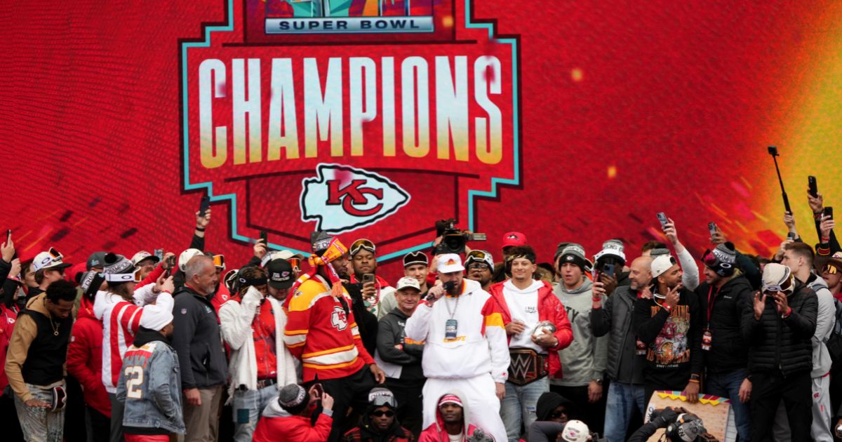 Travis Kelce #87 and Patrick Mahomes #15 of the Kansas City Chiefs celebrate on stage with teammates during the Kansas City Chiefs Super Bowl LVII victory parade on Feb. 15 in Kansas City, Missouri.