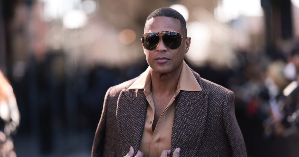 Don Lemon is wearing a beige brown shirt and matching pants, a brown coat and dark shades before the Michael Kors show on Wednesday in New York City.