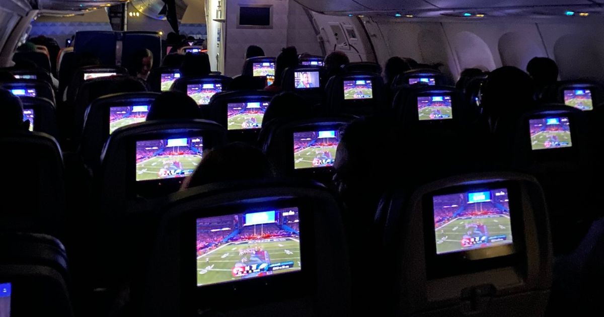 The above image shows individuals watching the Super Bowl on a flight Sunday.