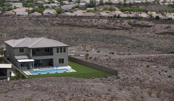 a home with a swimming pool abuts the desert on the edge of the Las Vegas valley