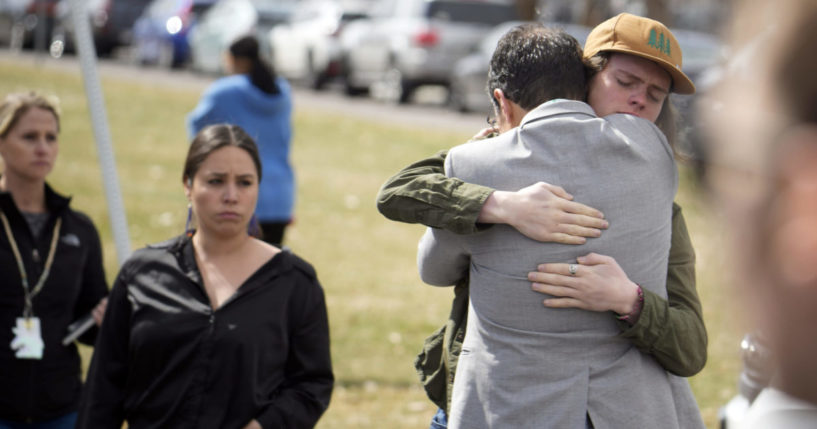 A student hugging a parent following a school shooting