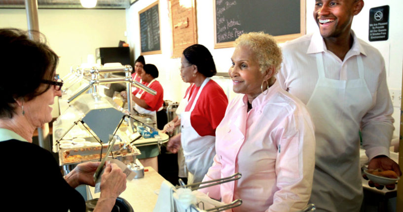 A customer picks up some food to-go from Sweetie Pie's owner Robbie Montgomery, center, and Montgomery's son, James "Tim" Norman, right, at Sweetie Pie's in St. Louis in 2011. Norman, the former star of a St. Louis-based TV reality show, was sentenced on Thursday to life in prison.