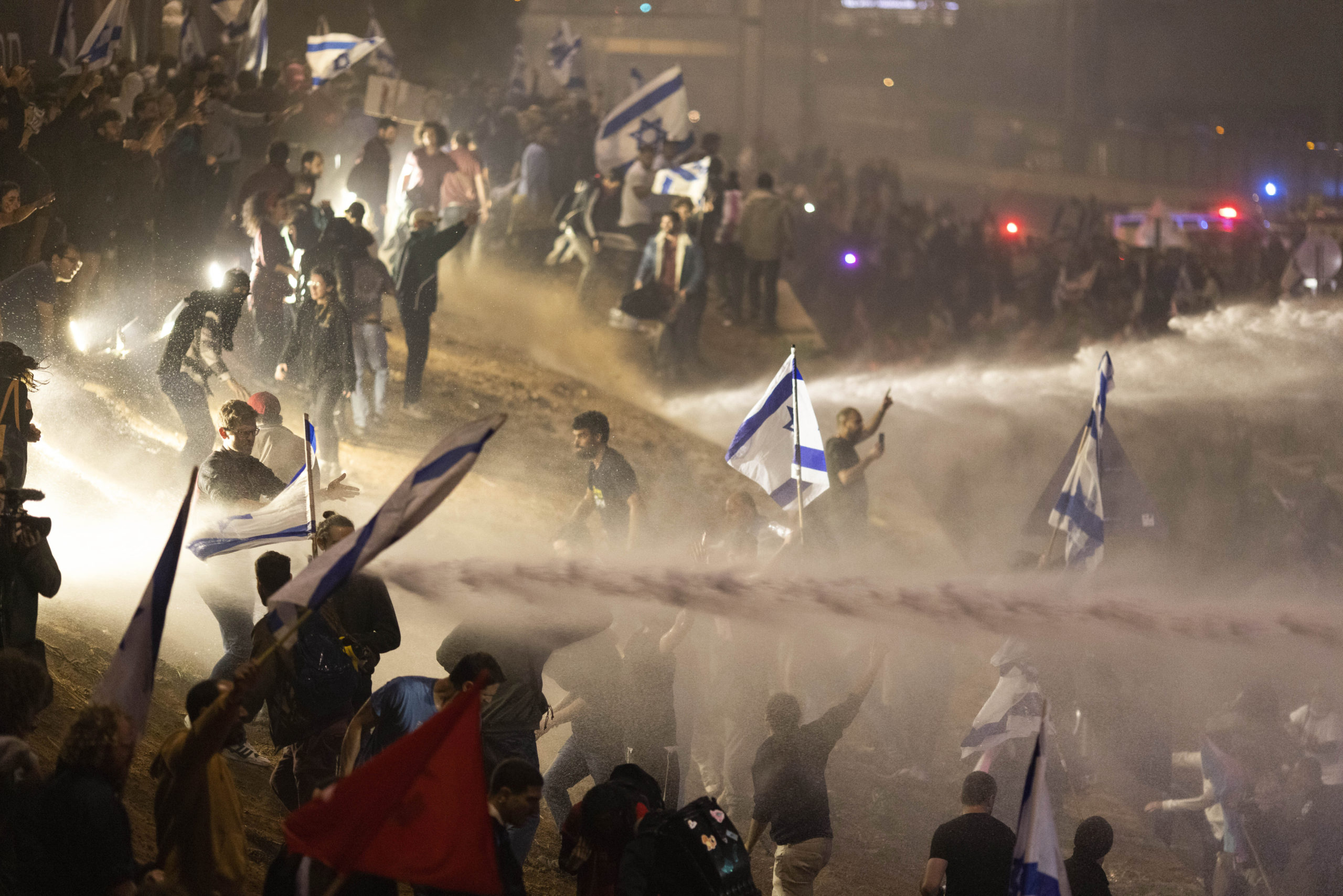 Israeli police use a water cannon to disperse demonstrators blocking a highway during a protest against plans by Prime Minister Benjamin Netanyahu's government to overhaul the judicial system in Tel Aviv, Israel, on Monday.