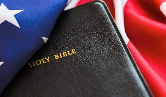 A Bible rests on an American flag in this stock image.