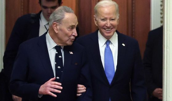 Senate Majority Leader Chuck Schumer, left, and President Joe Biden, right, walks through the U.S. Capitol in Washington, D.C., on Thursday.
