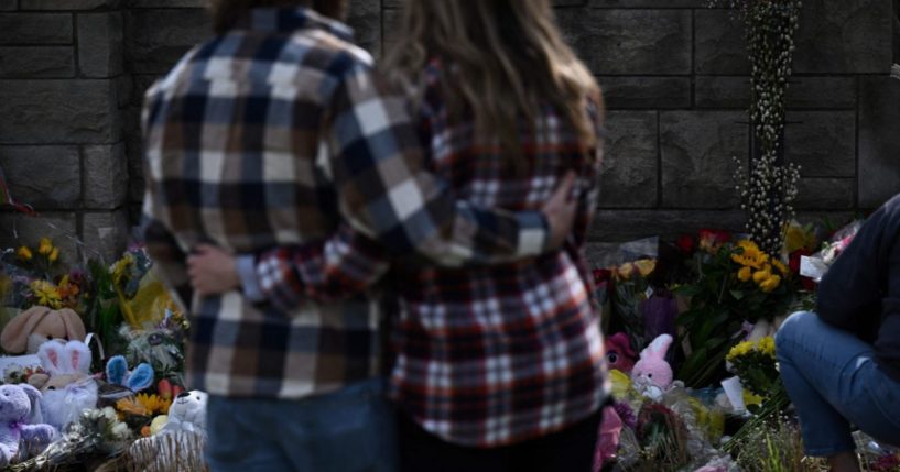 A couple stands in front of a makeshift memorial for the victims of The Covenant School shooting outside of the Covenant Presbyterian Church in Nashville, Tennessee, on Tuesday.