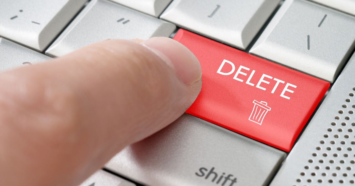 This stock photo shows a person pressing the "delete" button on a computer keyboard.