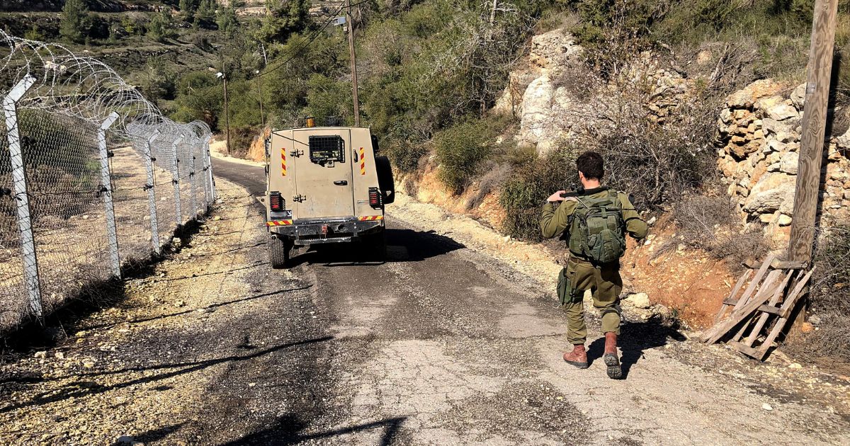 An Israel Defense Force soldier inspects a security fence. 