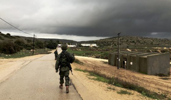 An Israel Defense Force soldier walks by a shooting range on a rainy day.