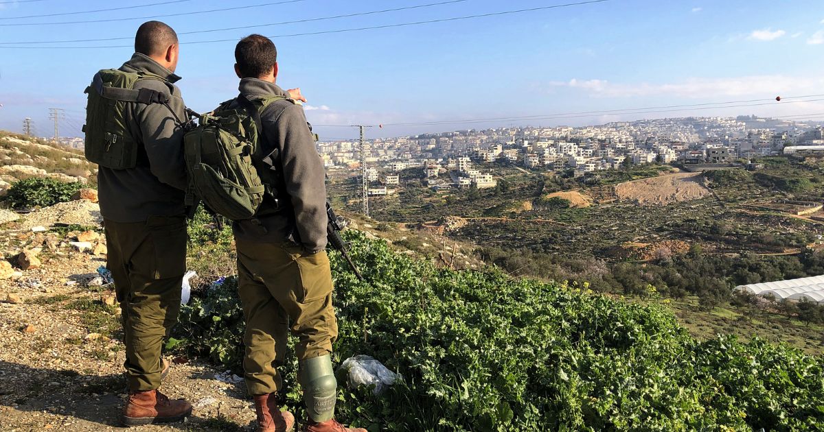 Israel Defense Force soldiers overlook a Palestinian town.