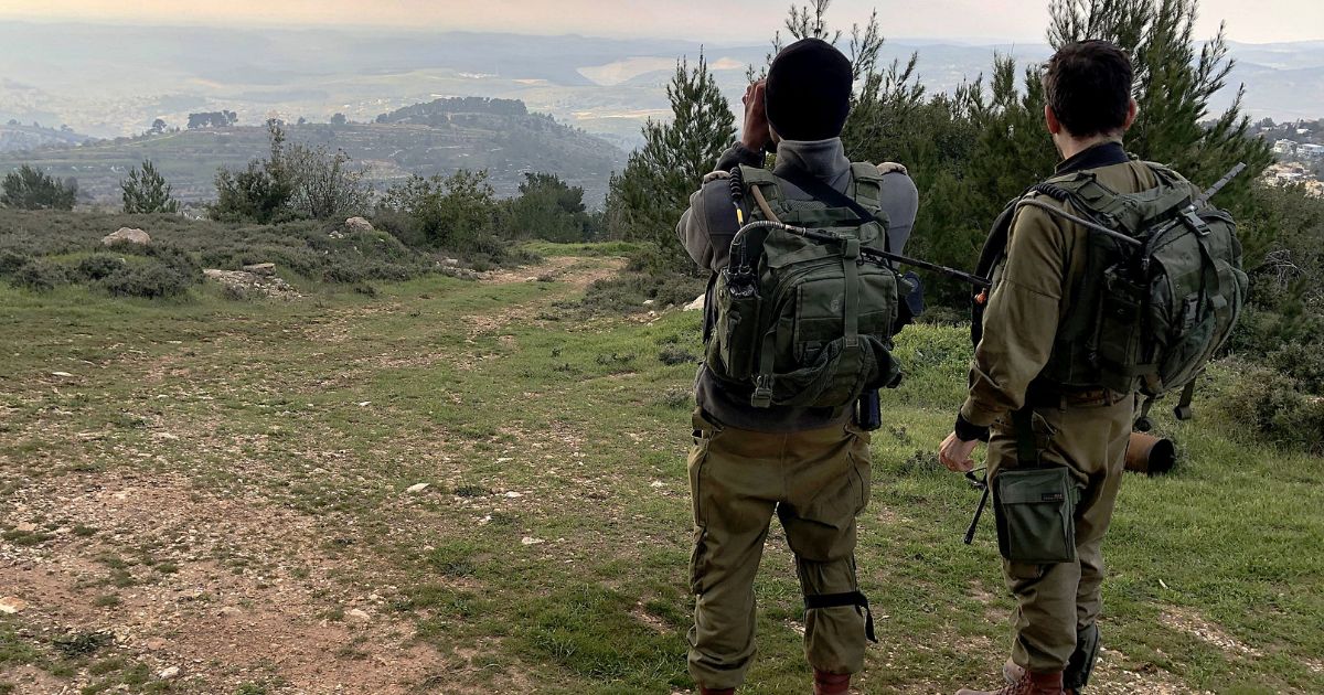 Israel Defense Force soldiers observe a Palestinian village.