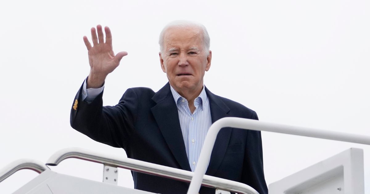 President Joe Biden waving as he boards Air Force One