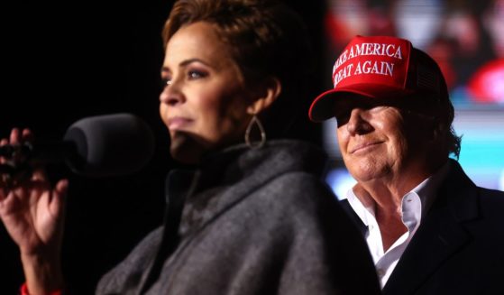 Kari Lake speaks as former President Donald Trump looks on at a rally on Jan. 15, 2022, in Florence, Arizona.
