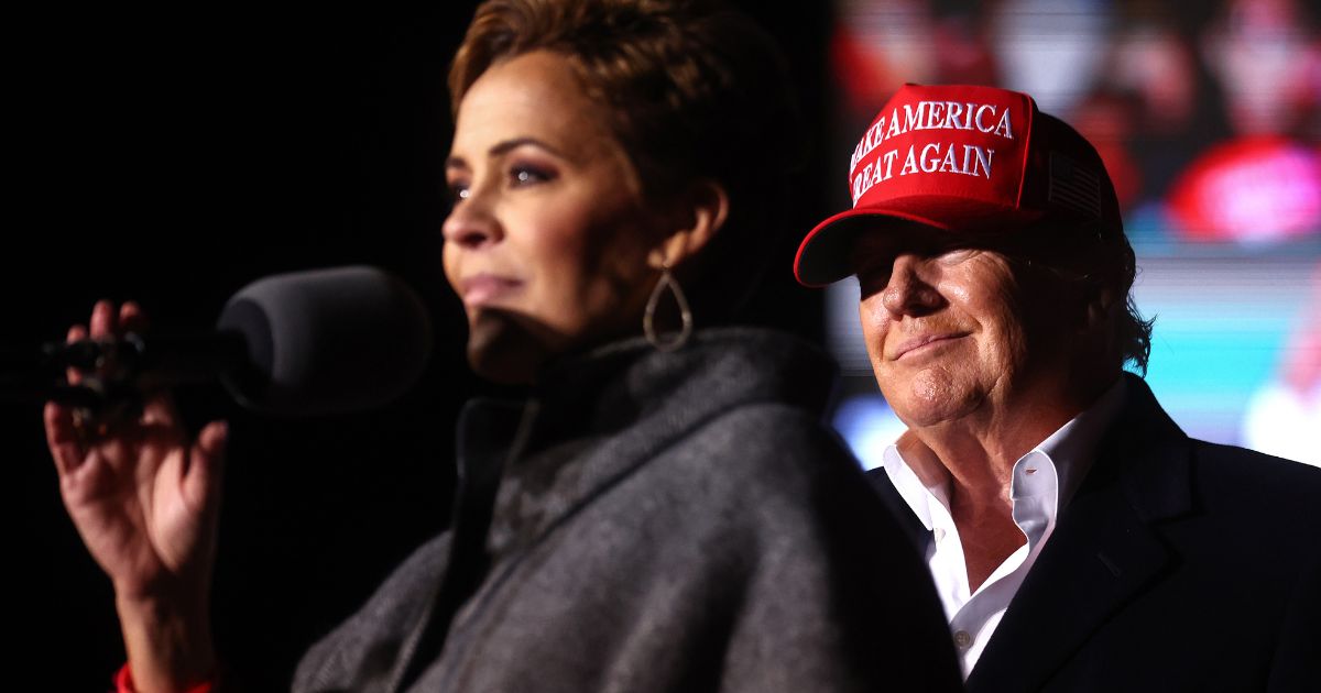 Kari Lake speaks as former President Donald Trump looks on at a rally on Jan. 15, 2022, in Florence, Arizona.