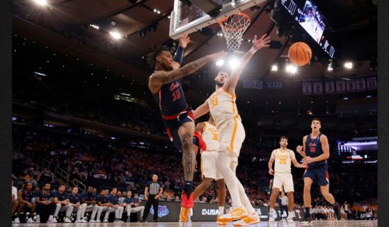 Alijah Martin, #15, of the Florida Atlantic Owls, passes the ball against Uros Plavsic, #33, of the Tennessee Volunteers, during the second half in the Sweet 16 round game of the NCAA Men's Basketball Tournament at Madison Square Garden on Thursday in New York City.