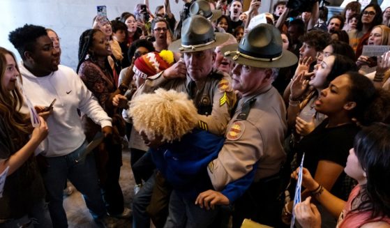 State troopers briefly detain one of the demonstrators who stormed Tennessee State Capitol in Nashville on Thursday to demand gun control.