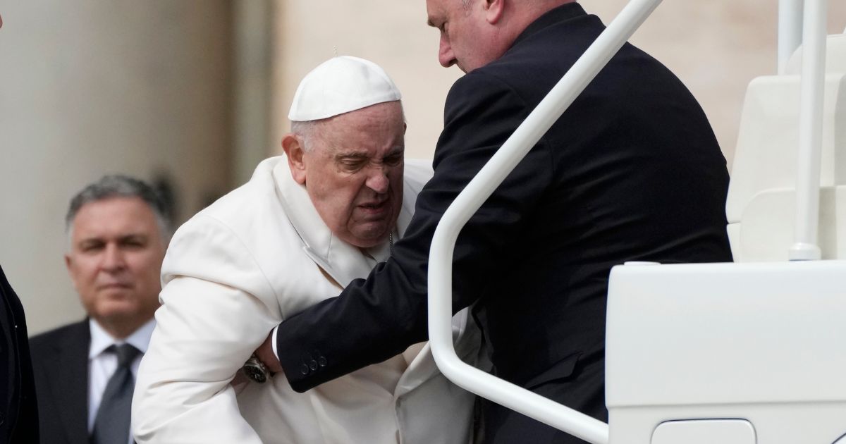 Pope Francis being helped to get on his car