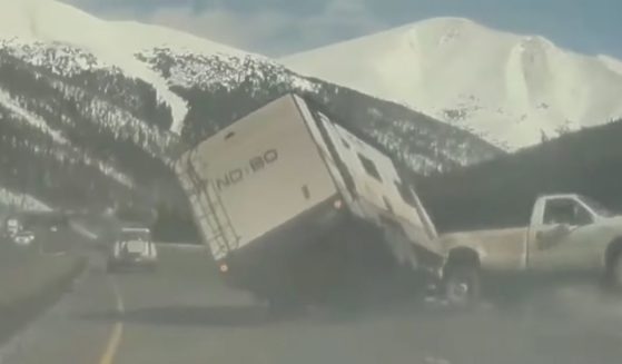 A travel trailer twisted and flipped, evidently after striking a pothole on a Colorado highway.