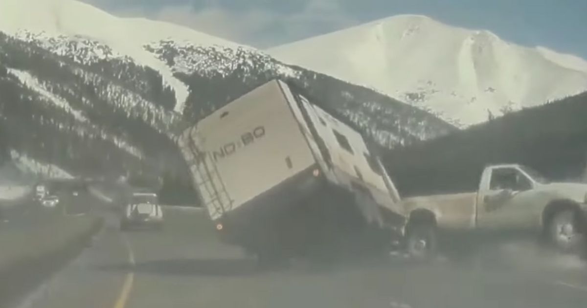 A travel trailer twisted and flipped, evidently after striking a pothole on a Colorado highway.