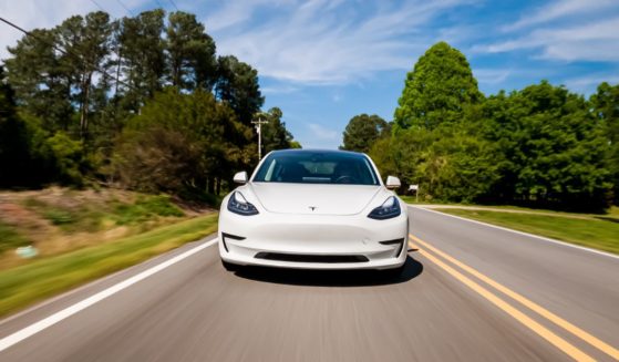 A stock photo shows a Tesla Model 3 electric vehicle driving on a country road near Raleigh, North Carolina, on April 17, 2020.