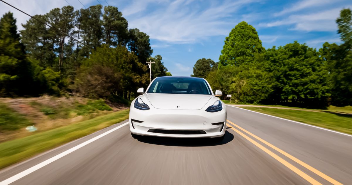 A stock photo shows a Tesla Model 3 electric vehicle driving on a country road near Raleigh, North Carolina, on April 17, 2020.