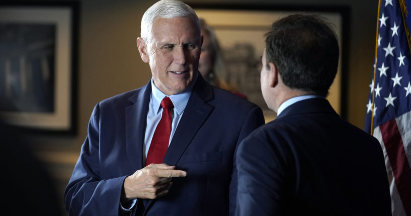 Former Vice President Mike Pence greets people while signing copies of his book "So Help Me God" before the start of a GOP fundraising dinner on Thursday in Keene, New Hampshire.