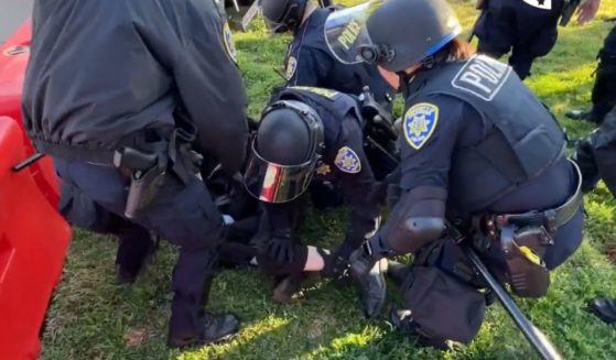Police are seen stopping individuals that were trying to block the entrance to Charlie Kirk's speech in California.