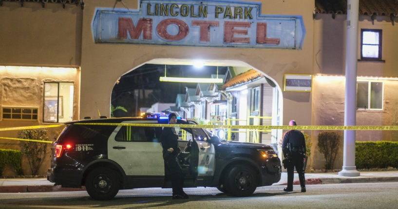 Police officers stand guard near a crime scene where three Los Angeles officers were shot Wednesday in the city's Lincoln Heights neighborhood. Police said the officers were hospitalized in stable condition.