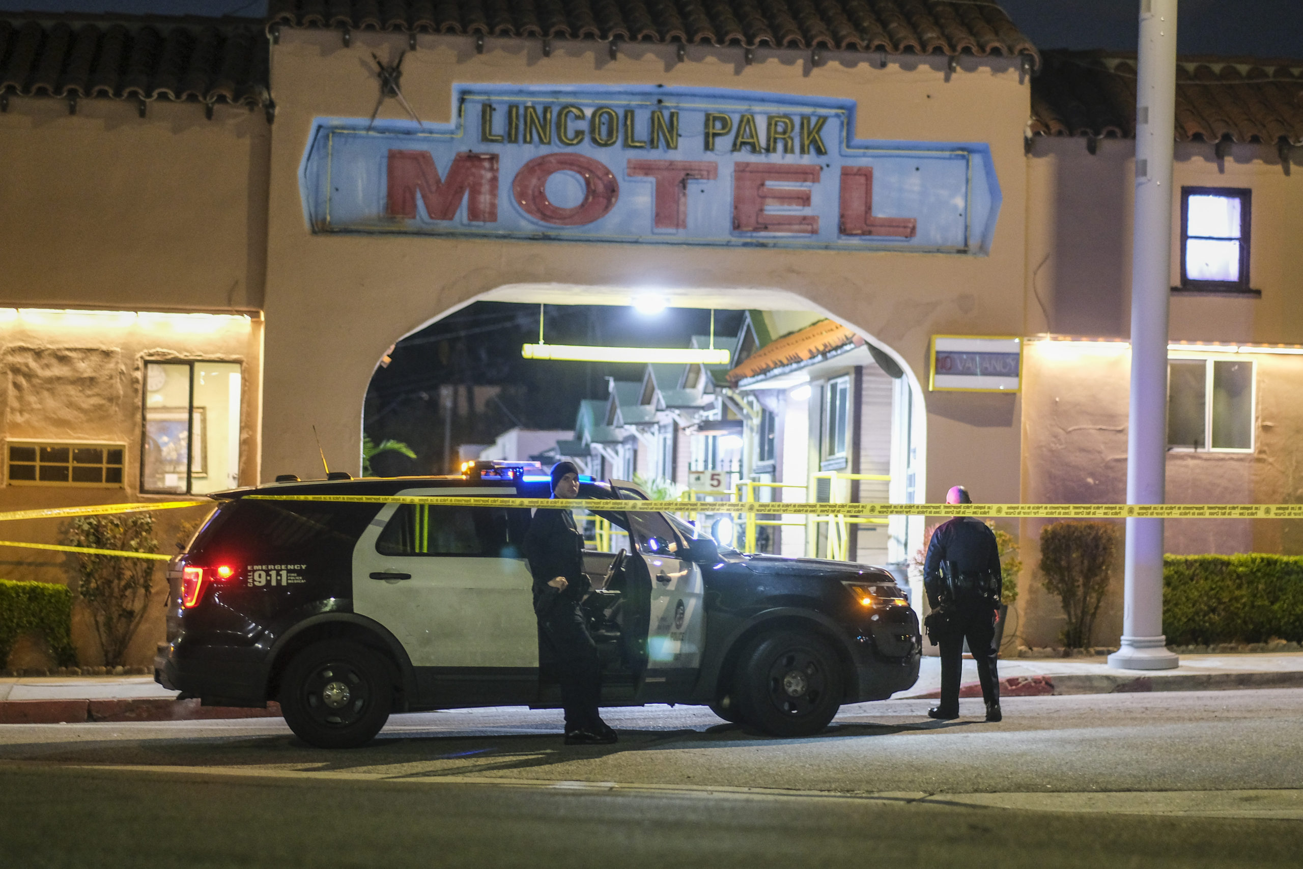 Police officers stand guard near a crime scene where three Los Angeles officers were shot Wednesday in the city's Lincoln Heights neighborhood. Police said the officers were hospitalized in stable condition.