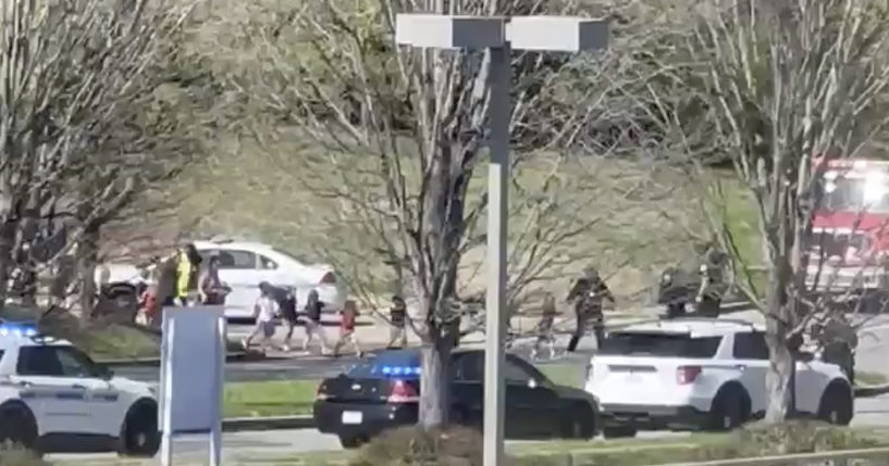 Law enforcement officers lead children away from the scene of a shooting at The Covenant School, a private Christian school in Nashville on Monday.