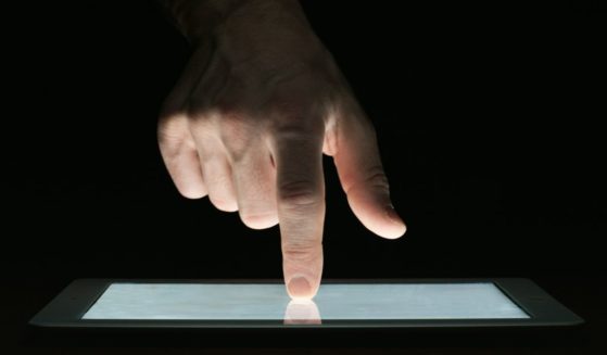 A man uses a tablet in the above stock image.