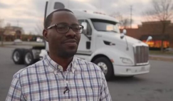 Jerry Johnson, a North Carolina resident and owner of a small trucking company, stands with a semi in the background.