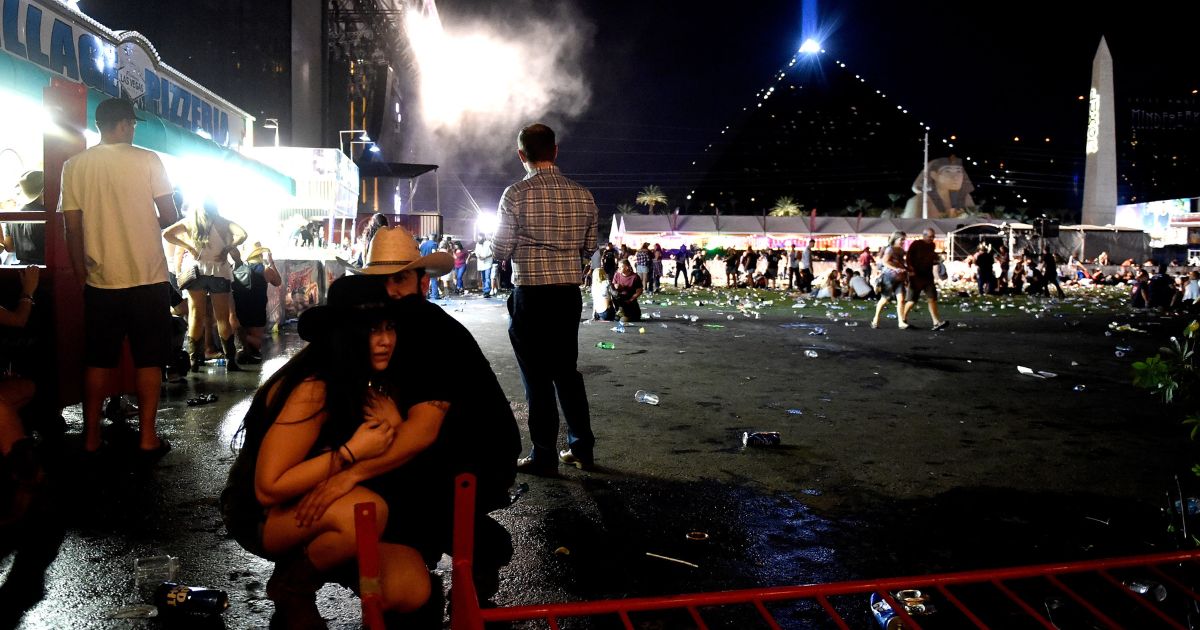 People take cover at the Route 91 Harvest country music festival after apparent gun fire was heard on Oct. 1, 2017, in Las Vegas.