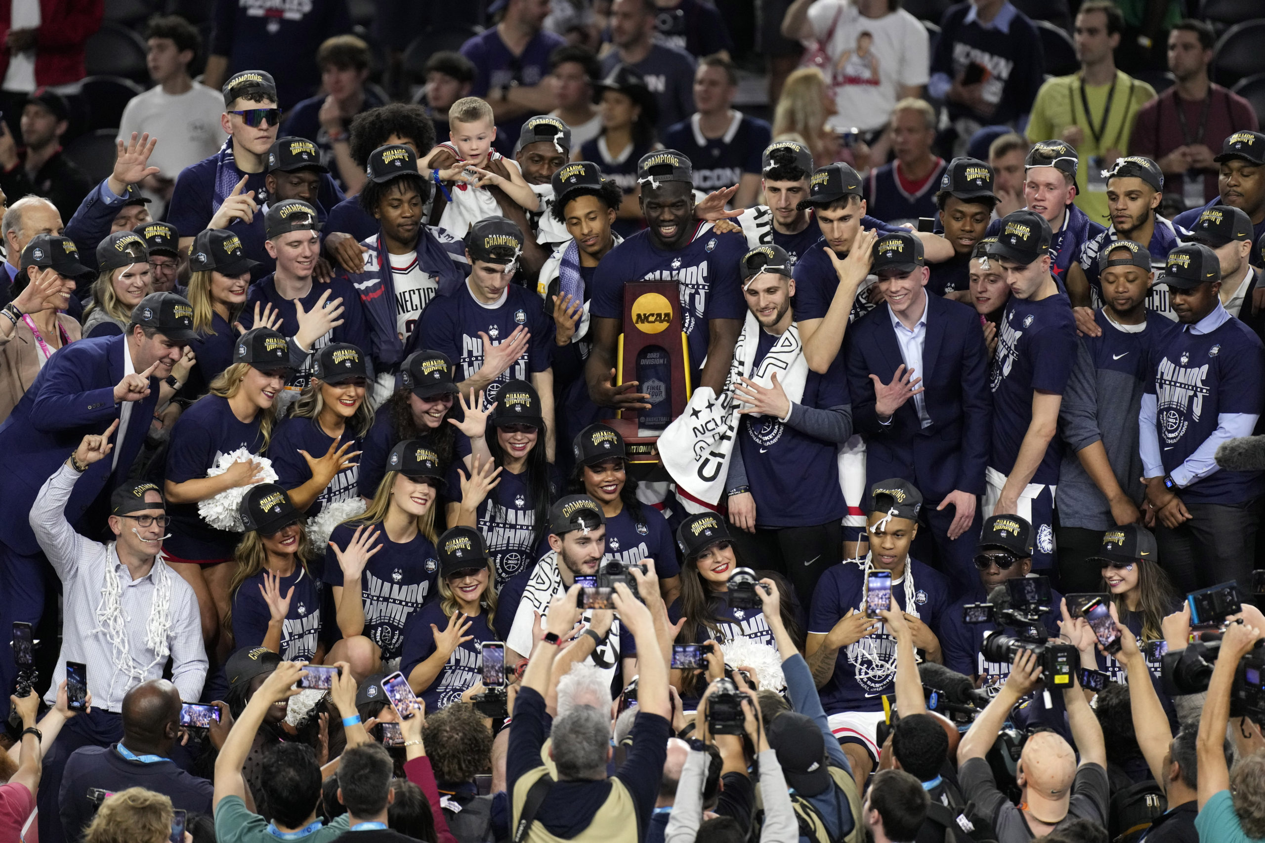 Players for UConn pose with coaches after winning the NCAA Tournament over San Diego State in Houston, Texas, on Monday night.