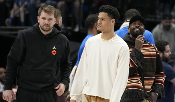Dallas Mavericks' Luka Doncic, left, Josh Green, center, and Kyrie Irving, right, stand on the court during a timeout in the second half of an NBA basketball game against the Chicago Bulls, Friday, April 7, 2023, in Dallas.